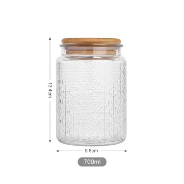 Wholesale embossed surface empty food grade glass storage jar with bamboo lid